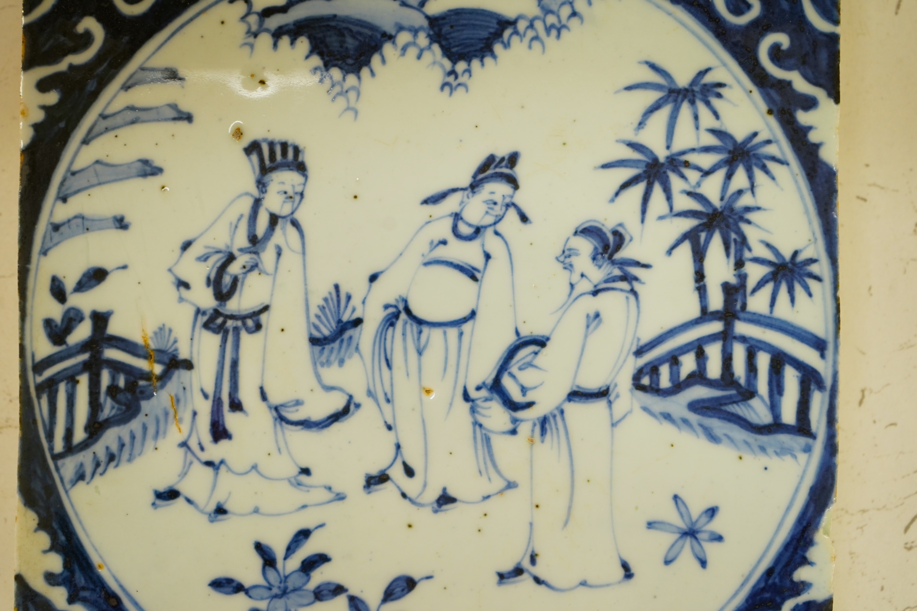 A Chinese tile depicting three figures, 20cm wide